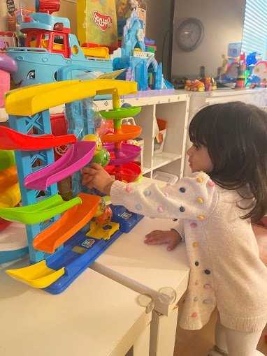 Infant playing with a colorful toy at Happy Palm Daycare Irvine